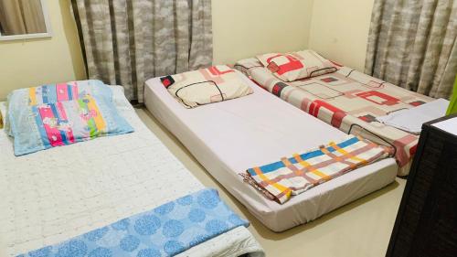 2 camas individuales en una habitación con 3 camas individuales que establece que en Pagadian City House Rental - Hidehouse en Pagadían​