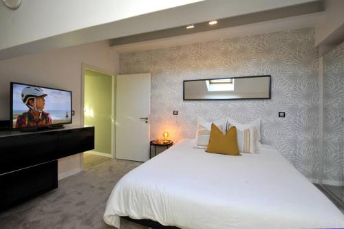 een slaapkamer met een groot bed en een flatscreen-tv bij LE CHALEUREUX 60M2 à 200M Place Stanislas in Nancy