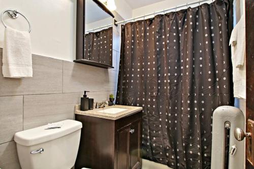 a bathroom with a toilet and a shower curtain at 1BR Homey Apt in Irving Park - Troy 2 in Chicago