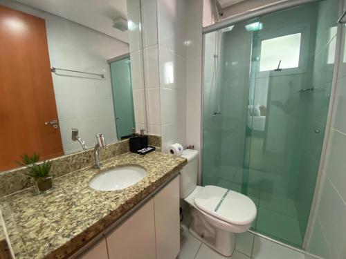 La salle de bains est pourvue de toilettes, d'un lavabo et d'une douche en verre. dans l'établissement Aconchegante apto 2/4 Setor Bueno 1307, à Goiânia