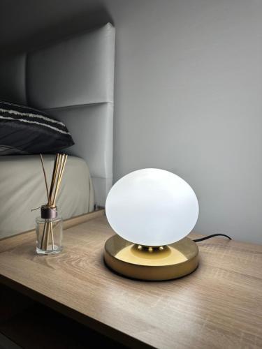 a lamp on a table next to a bed at Velvet Vista in Štip