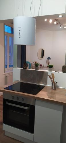 une cuisine avec une cuisinière et un comptoir dans l'établissement Le Sunny-Appartement duplex spacieux, à Outreau