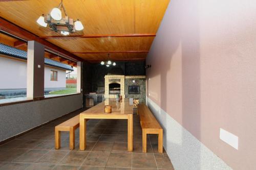 a dining room with a wooden table and benches at Котедж "Валерія" in Vorokhta