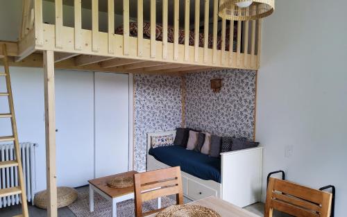 um pequeno quarto com um beliche e uma mesa em Studio Gypsy em Isigny-le-Buat