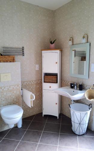 uma casa de banho com um lavatório branco e um WC. em Studio Gypsy em Isigny-le-Buat
