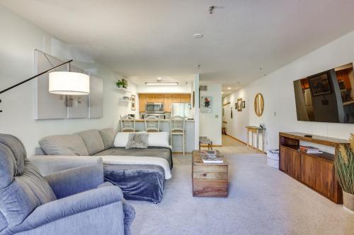 a living room with a couch and a table at Walkable Frisco Condo Mtn Views and Shared Hot Tub! in Frisco