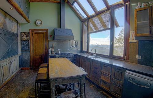 cocina con fregadero y ventana grande en Nepenpiren en San Martín de los Andes