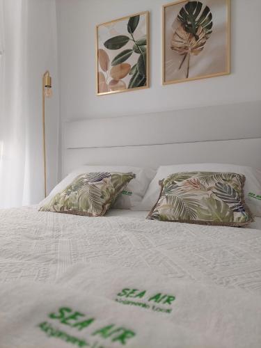 - un lit blanc avec 2 oreillers dans l'établissement SEA AIR Alojamento Local, à Nazaré
