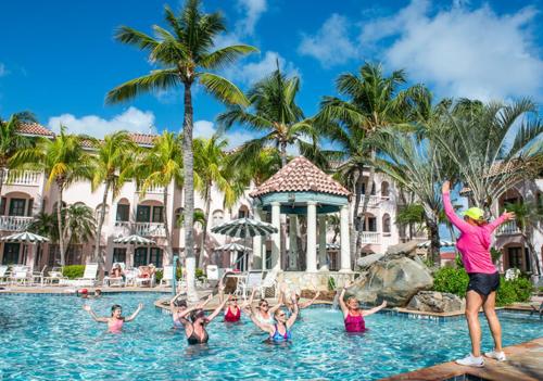 um grupo de pessoas na água em um resort em Caribbean Palm Village Resort em Palm-Eagle Beach