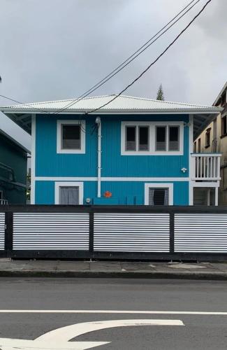 a blue and white house on the side of a street at Downtown Hilo Apt L in Hilo
