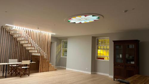 a living room with a staircase and a table and chairs at Matriz 55, Hostel & Suites in Ponta Delgada