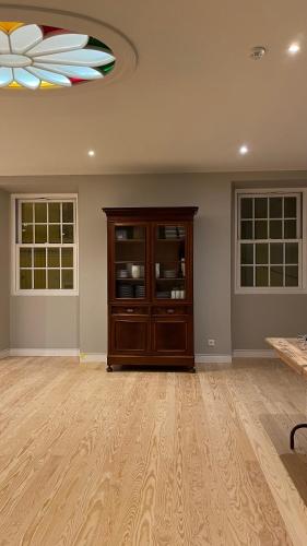 a room with a wooden cabinet and two windows at Matriz 55, Hostel & Suites in Ponta Delgada