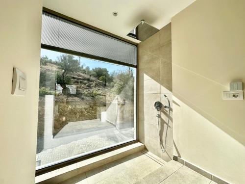 y baño con ducha y ventana grande. en Topos luxury stay Heraion en Loutraki