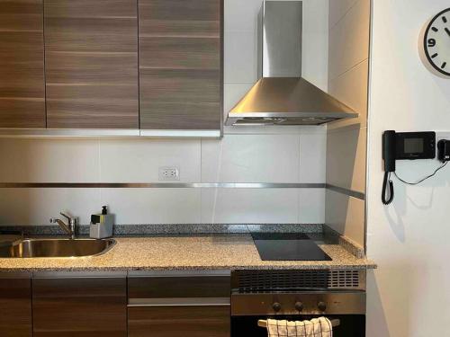 a kitchen with a stove and a sink and a clock at Departamento para dos personas- Barrio Camba Cua in Corrientes