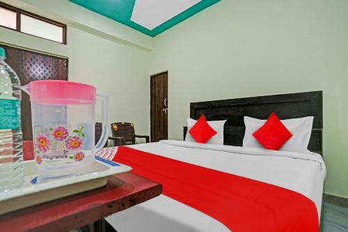 - une chambre avec un lit et une couette rouge et blanche dans l'établissement OYO Flagship Green Well Hotel & Restaurant, à Rewāri