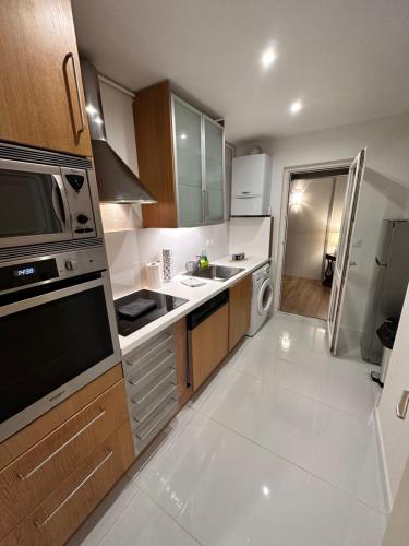 une petite cuisine avec un évier et un micro-ondes dans l'établissement Le bijou de Leyna, à Colmar