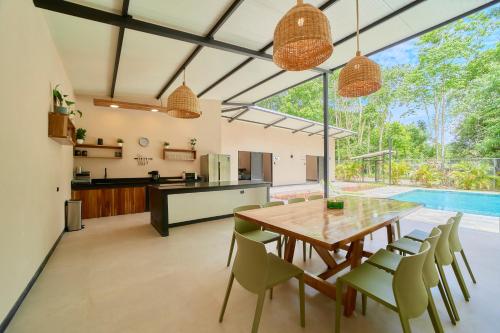 an open kitchen and dining room with a wooden table and chairs at LaLola Villa Privada in Cahuita
