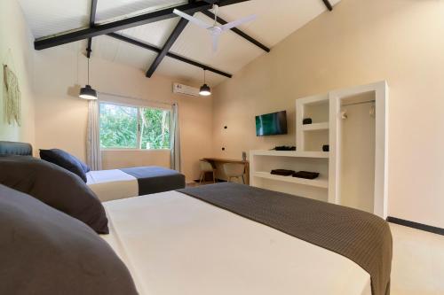 1 dormitorio con 2 camas y ventana en LaLola Villa Privada, en Cahuita