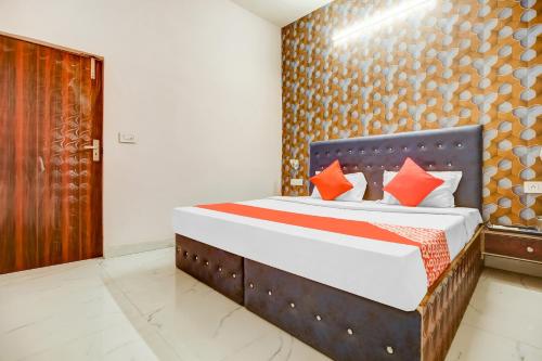 sypialnia z dużym łóżkiem z pomarańczowymi poduszkami w obiekcie Flagship Hotel 3k Inn w mieście Ludhiana