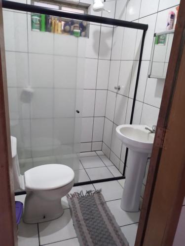 a bathroom with a shower and a toilet and a sink at Casa da paty in Santa Cruz Cabrália