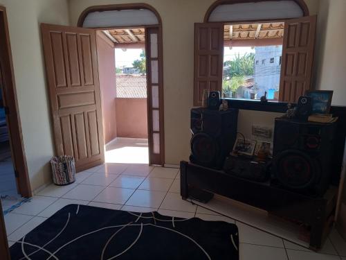 uma sala de estar com 2 portas e um quarto com piso em azulejo em Casa da paty em Santa Cruz Cabrália