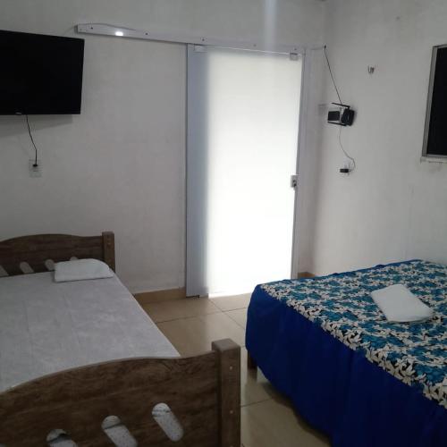 a room with two beds and a laptop on a table at Pousada da Rotatória in São Gonçalo do Amarante