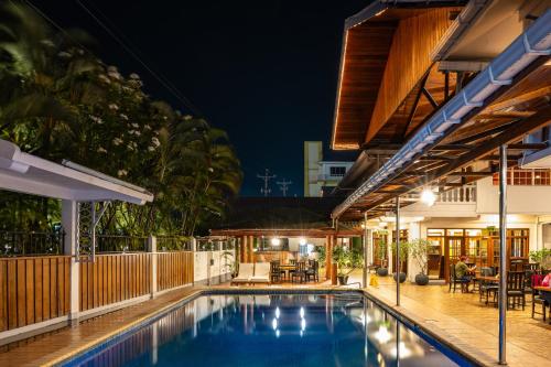 een buitenzwembad in een huis 's nachts bij Grand Coastal Hotel in Georgetown