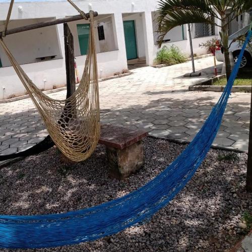 a hammock and a bench on a sidewalk at Pousada da Rotatória in São Gonçalo do Amarante