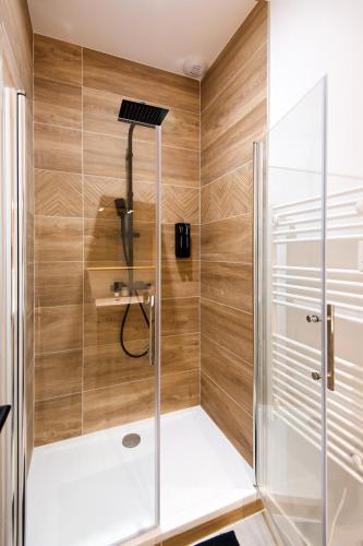 une douche avec une porte vitrée dans une salle de bain dans l'établissement Magnifique T3 totalement rénové, hypercentre Rochefort, arrivée autonome !, à Rochefort