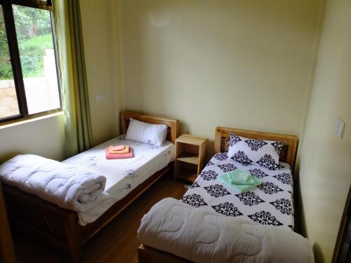 Habitación con 2 camas y ventana en Enjivai Hostel, en Arusha