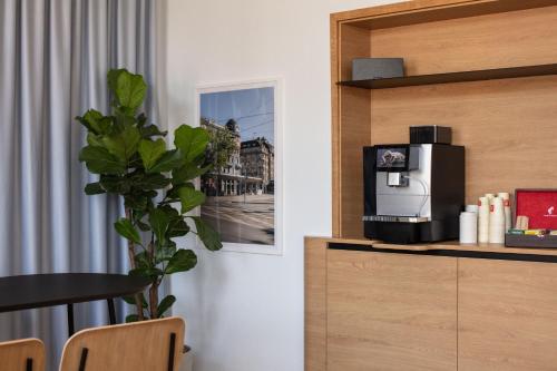 a room with a coffee maker on a shelf at Fred Guest House Hauptbahnhof - Mobile Check-in in Zürich