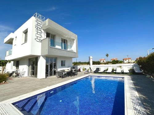 a villa with a swimming pool in front of a house at Protaras LUX Villa, Swimming pool, BBQ grill, Near beach in Protaras