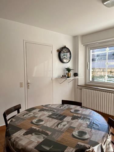 une salle à manger avec une table et une horloge au mur dans l'établissement Le Crozet, à Arçon
