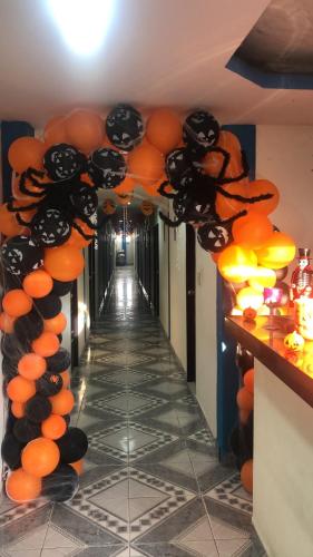 a corridor with orange and black balloon decorations at HOSTAL BOCA CHICA in Cartagena de Indias