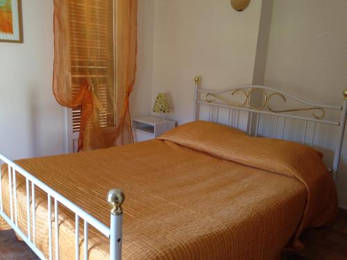 FarinoleにあるMaison Les Pieds dans l eauのベッドルーム1室(オレンジ色の毛布付きのベッド1台付)
