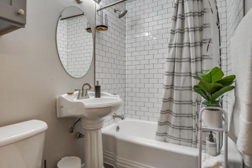 a bathroom with a sink and a toilet and a bath tub at Cozy Minneapolis Duplex - 10 Mi to Downtown! in Minneapolis