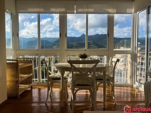 a dining room with a table and chairs in front of a window at El Capricho in Benicàssim