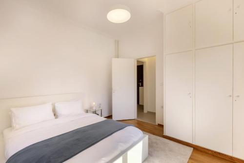 a white bedroom with a bed and white cabinets at Kerameikou25 small in Athens