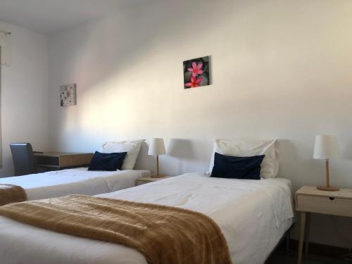 2 camas en una habitación con paredes blancas en Santiago Guesthouse en Aveiro