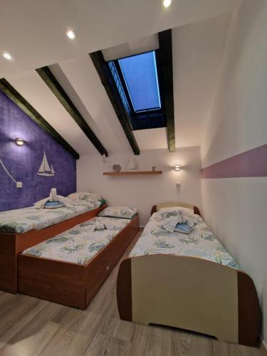 1 dormitorio con 2 camas y ventana en Apartments Marica, en Zadar