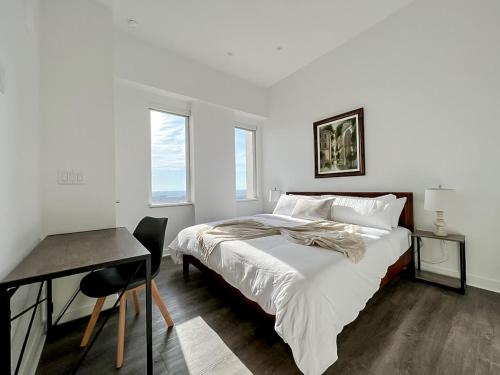 Habitación blanca con cama y escritorio en Sleepover Exclusive 1BD 1BA Downtown Kansas City Apartments, en Kansas City