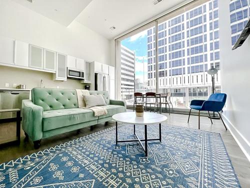 sala de estar con sofá verde y mesa en Sleepover Exclusive 1BD 1BA Downtown Kansas City Apartments, en Kansas City
