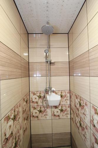 a shower with flowers on the wall in a room at Котедж "Валерія" in Vorokhta