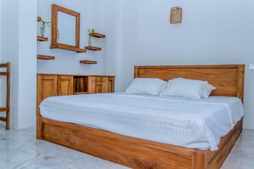 1 dormitorio con 1 cama grande y cabecero de madera en Aqualina Villa, en Matara