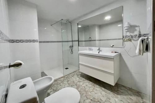 ein weißes Bad mit einem Waschbecken und einer Dusche in der Unterkunft CHINASOL Low Cost in Almuñécar
