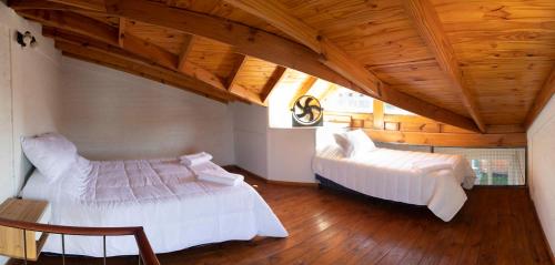 特雷弗林的住宿－Trevelin Houses，一间卧室设有两张床和木制天花板