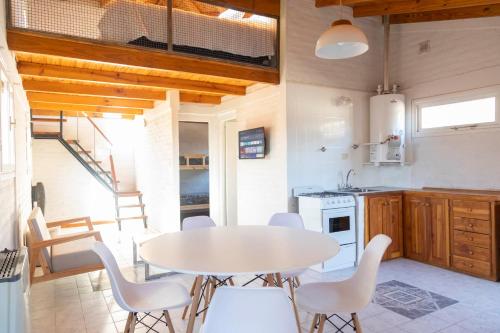 - une cuisine et une salle à manger avec une table et des chaises dans l'établissement Trevelin Houses, à Trevelín