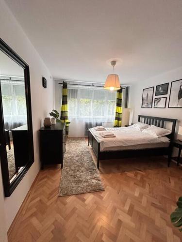 a bedroom with a bed and a large window at Charming treasure - City centre in Timişoara