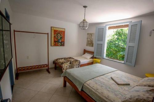 a bedroom with two beds and a window at Tranquilidade e Conforto em Guaramiranga in Guaramiranga