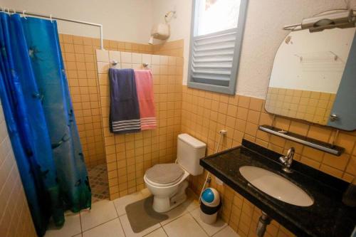 a bathroom with a toilet and a sink and a mirror at Tranquilidade e Conforto em Guaramiranga in Guaramiranga